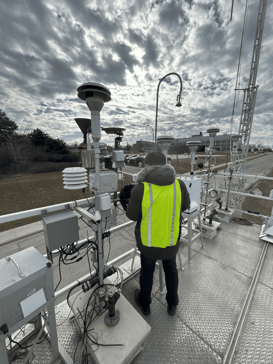 Person in day-glo vest looking at air quality monitors