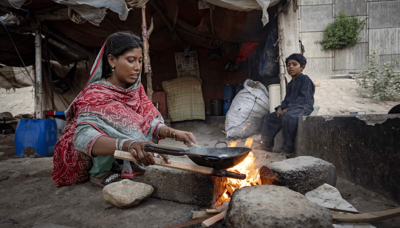 Woman cooking over open fire